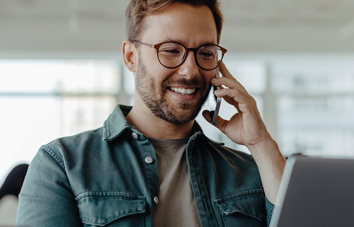 Man using an iPhone and MacBook