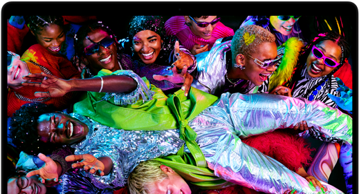 Colourful screen on a MacBook Pro of a person crowdsurfing at a party, showcasing the vibrant Liquid Retina XDR display